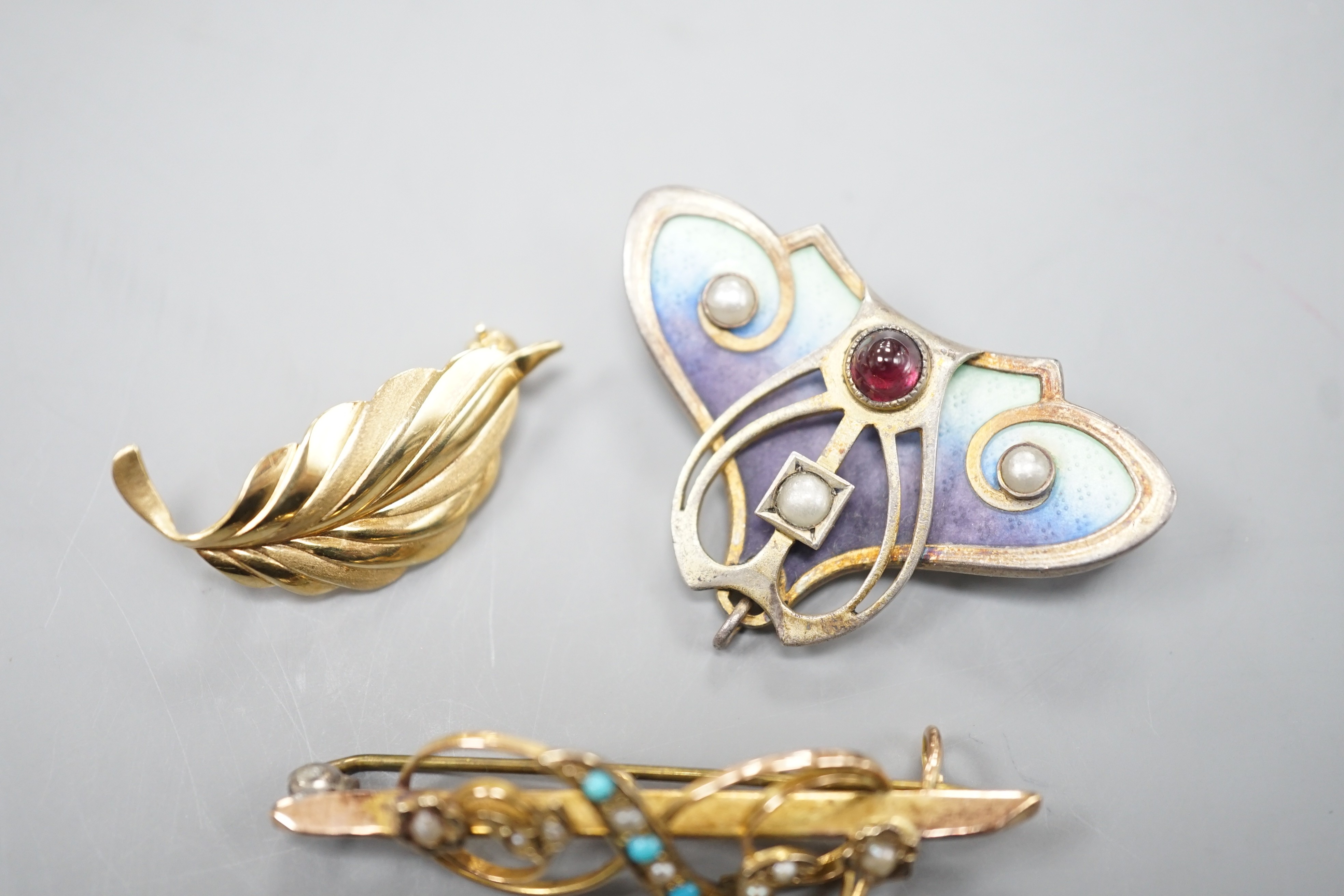 A continental Art Nouveau 900 gilt white metal, cabochon stone, seed pearl and enamel set brooch, 36mm and two 9ct brooches including gem set, 9ct gross 4.2 grams.